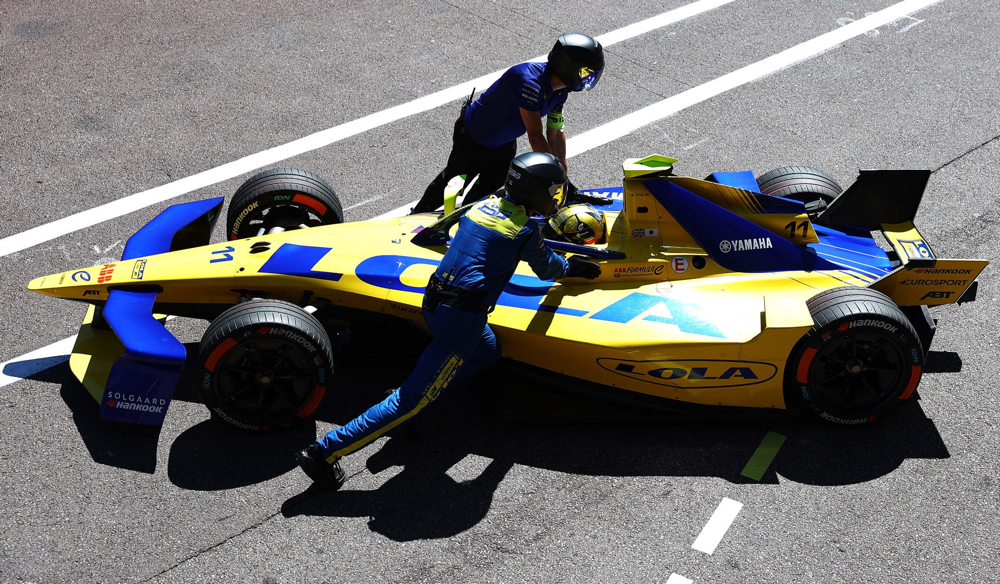 MONTE-CARLO, MÓNACO - 16 DE MAYO: Mechanics push the car of Lucas di Grassi de Brasil and Lola Yamah