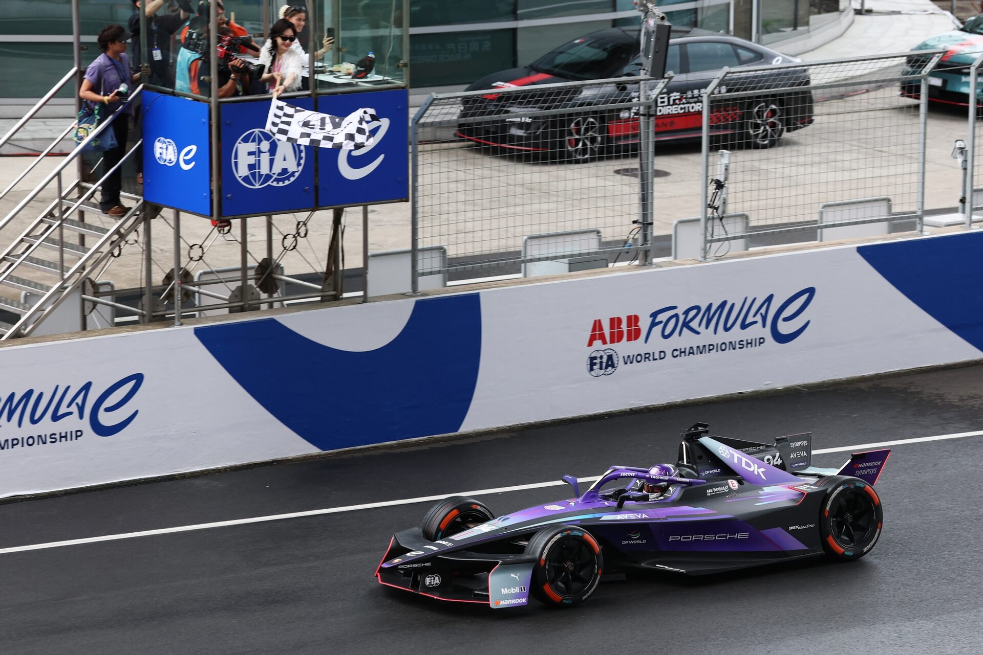 Chen Shu ondea la bandera a cuadros as Pascal Wehrlein de Alemania pilotando el (94) Porsche Formula E