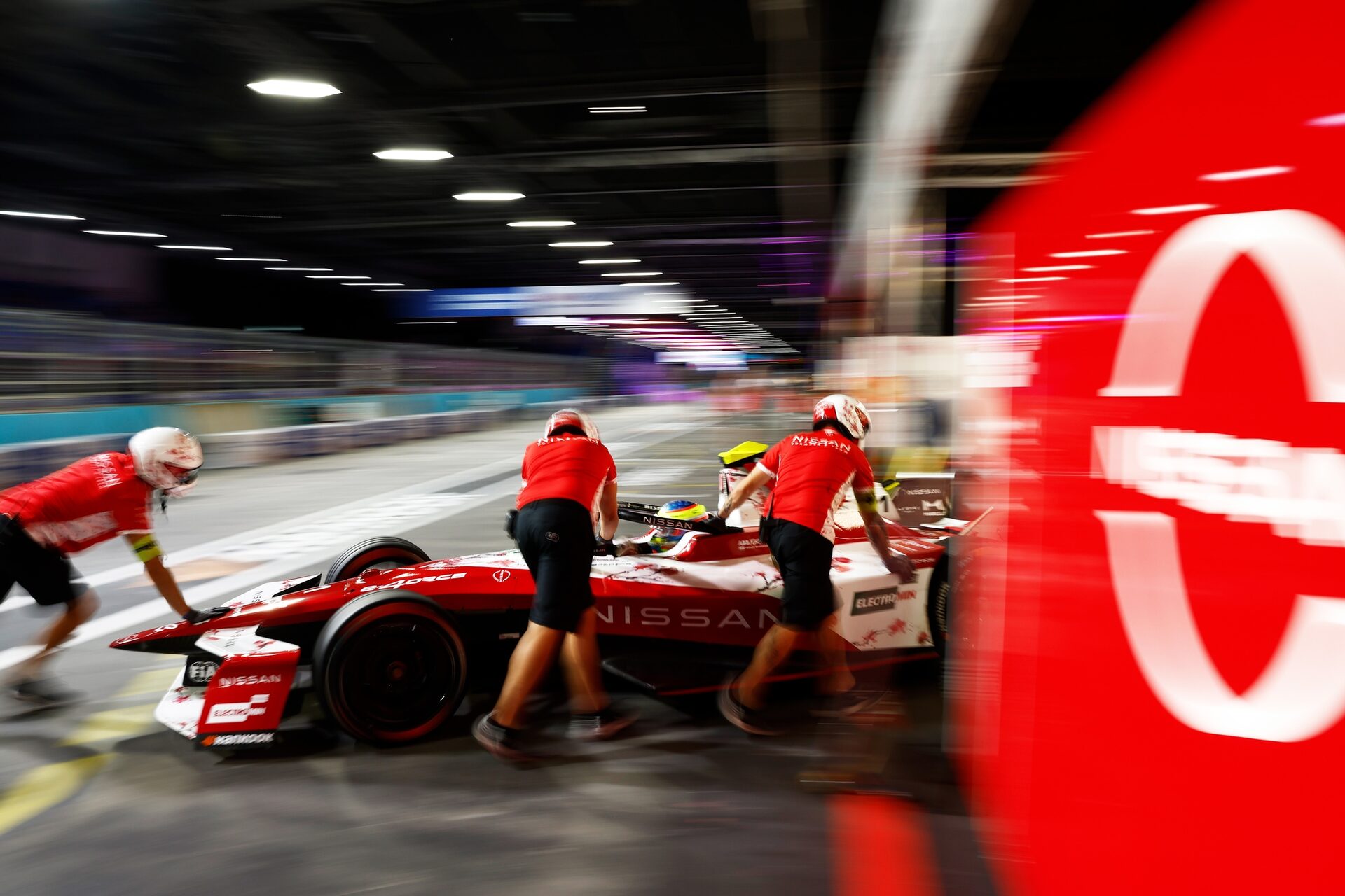 Team members push the car of Oliver Rowland de Gran Bretaña and Nissan Formula E Team into the garag